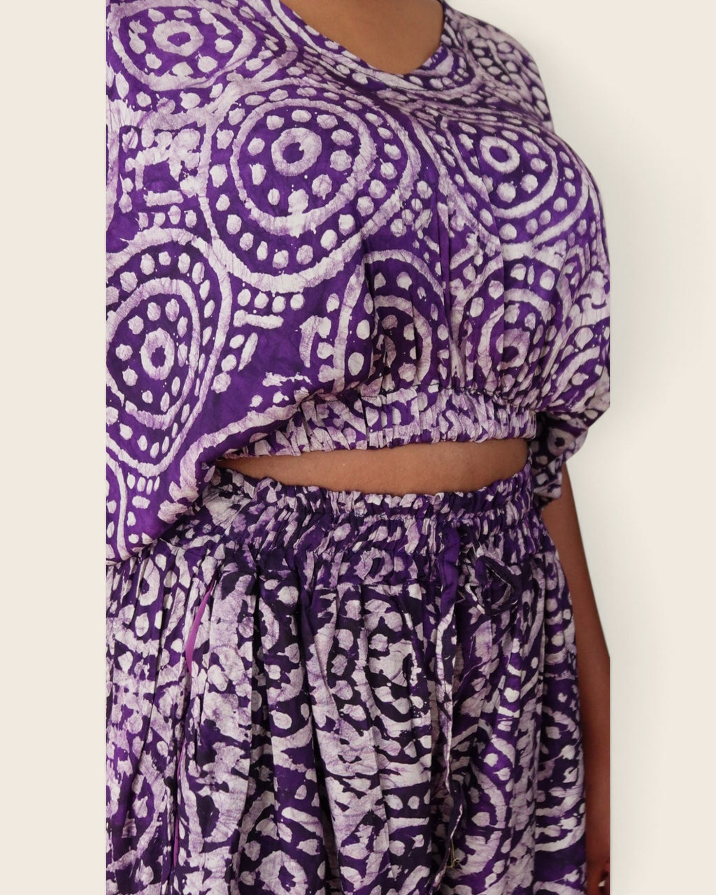 Simi Amethyst Medallion — hand-dyed Adire fabric detail, lilac dotted medallions on deep violet, close-up of the crop top and smocked waist, L'atelier KaAy