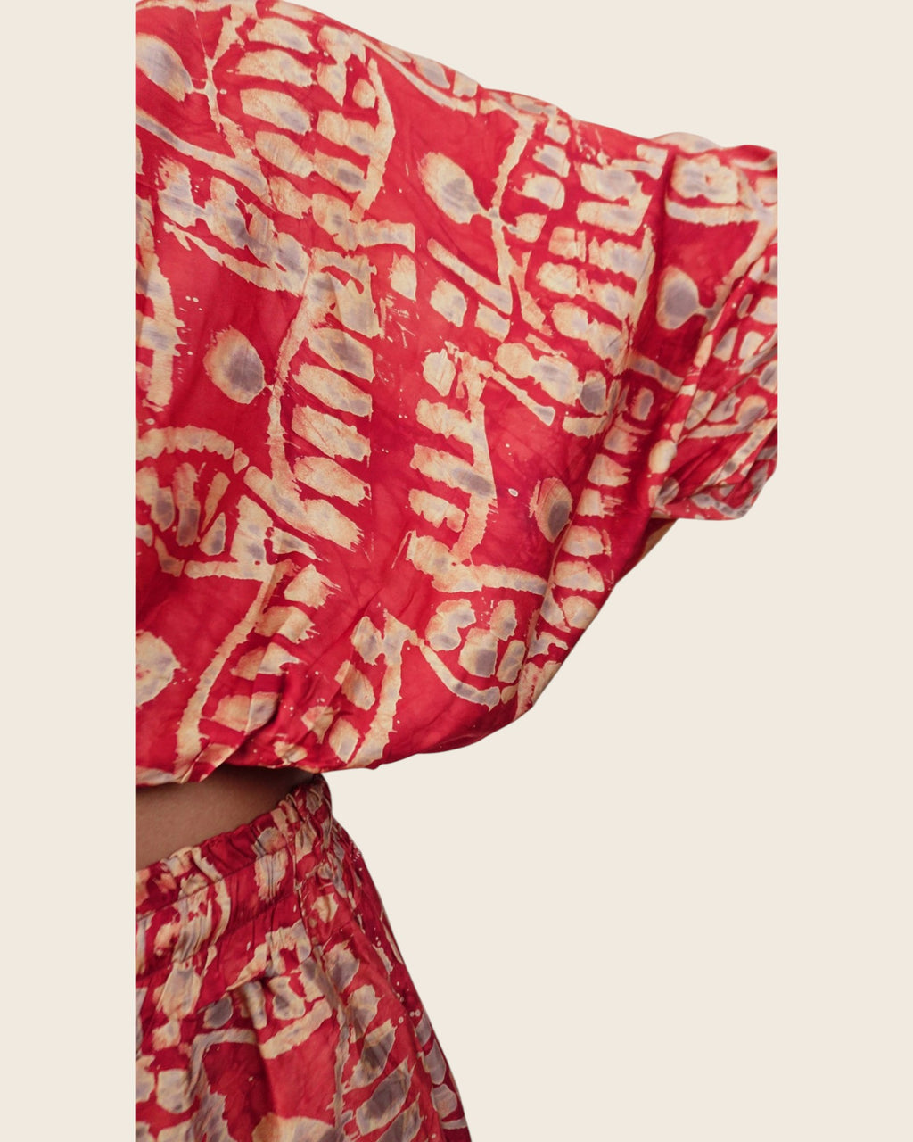 Simi Coral Fern — hand-dyed Adire fabric detail, sand fern motifs and smoky grey dots on coral red, close-up of the batwing sleeve, L'atelier KaAy
