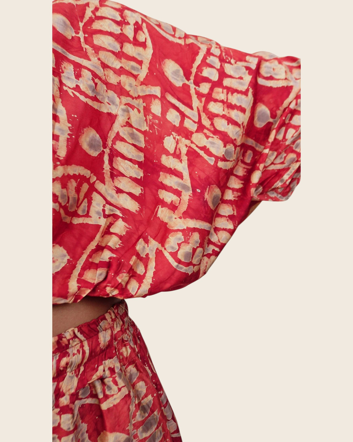 Simi Coral Fern — hand-dyed Adire fabric detail, sand fern motifs and smoky grey dots on coral red, close-up of the batwing sleeve, L'atelier KaAy