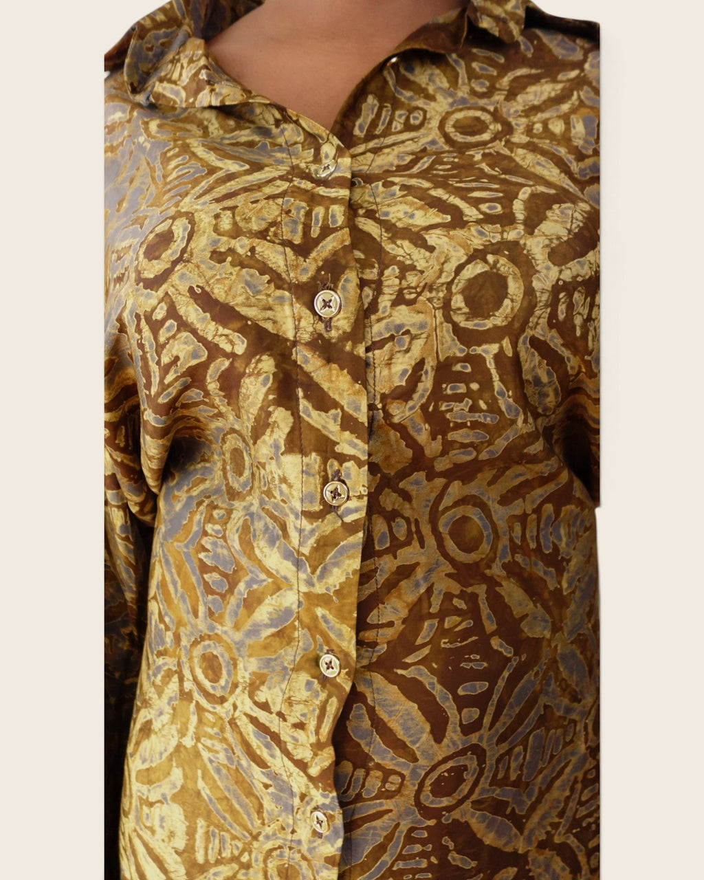 Adunni Golden Bark — hand-dyed Adire fabric detail, gold and soft grey medallions on bark brown, close-up of the collar and buttons, L'atelier KaAy