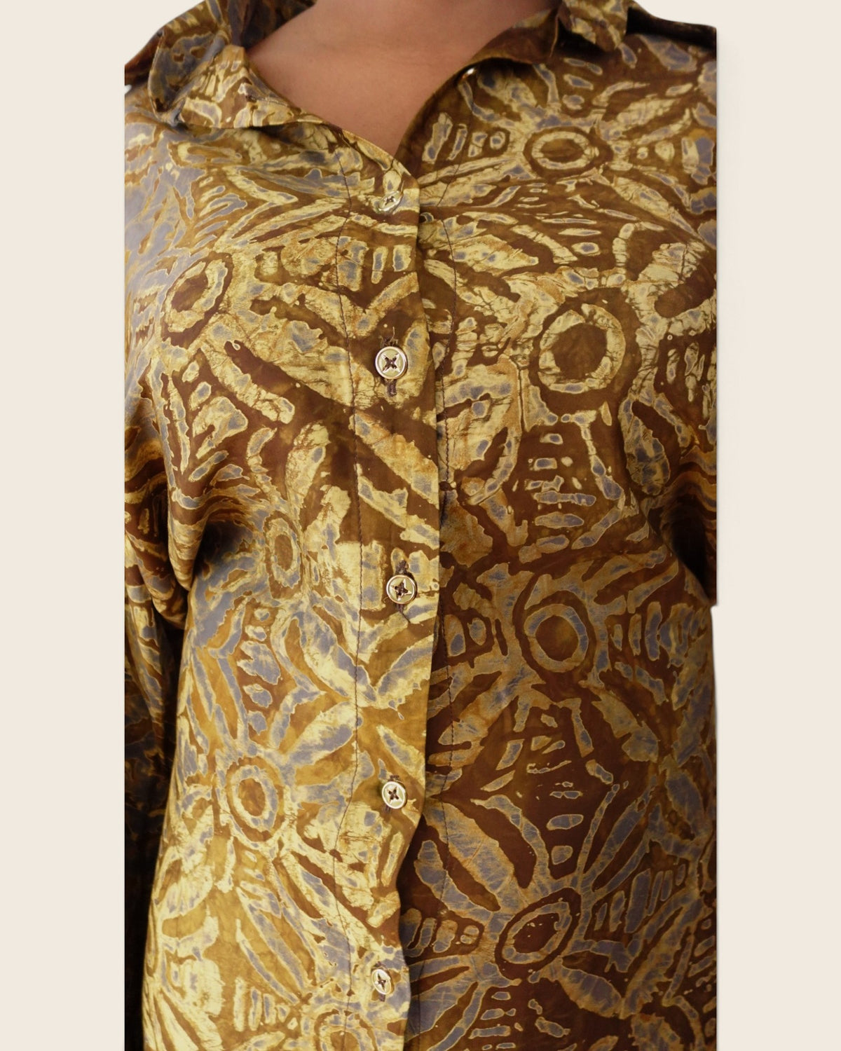 Adunni Golden Bark — hand-dyed Adire fabric detail, gold and soft grey medallions on bark brown, close-up of the collar and buttons, L'atelier KaAy