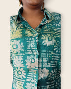 Adunni Teal Blossom — hand-dyed Adire fabric detail, ivory and lime flowers on deep teal, close-up of the collar and buttons, L'atelier KaAy