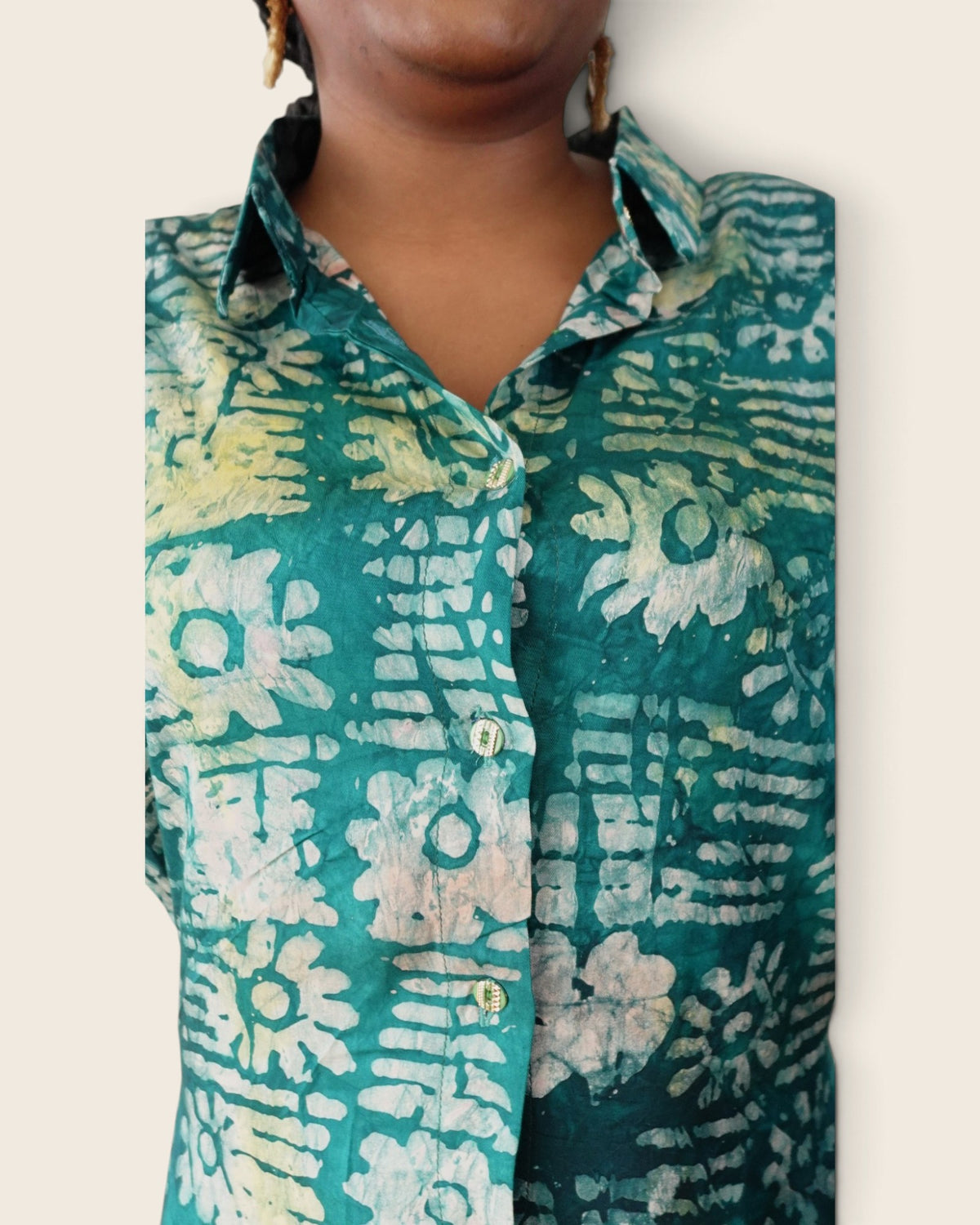 Adunni Teal Blossom — hand-dyed Adire fabric detail, ivory and lime flowers on deep teal, close-up of the collar and buttons, L'atelier KaAy