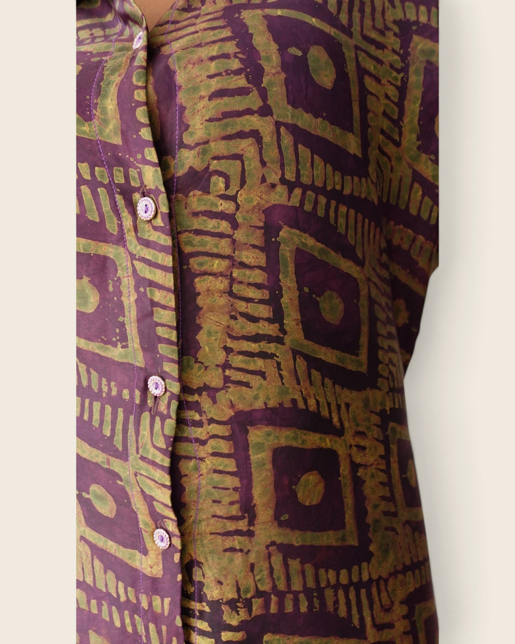 Adunni Fig Tile — hand-dyed Adire fabric detail, olive-gold squares on deep fig purple, close-up of the buttons, L'atelier KaAy