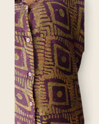 Adunni Fig Tile — hand-dyed Adire fabric detail, olive-gold squares on deep fig purple, close-up of the buttons, L'atelier KaAy