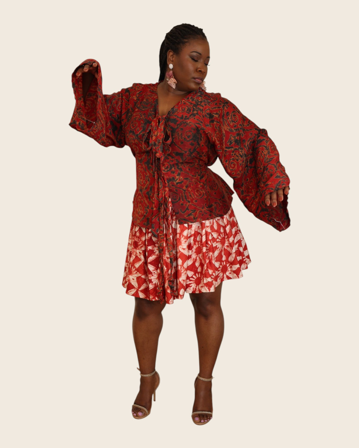 Aïna Ember Red — african print skirt set in hand-dyed Adire, front view, one bell sleeve raised, L'atelier KaAy