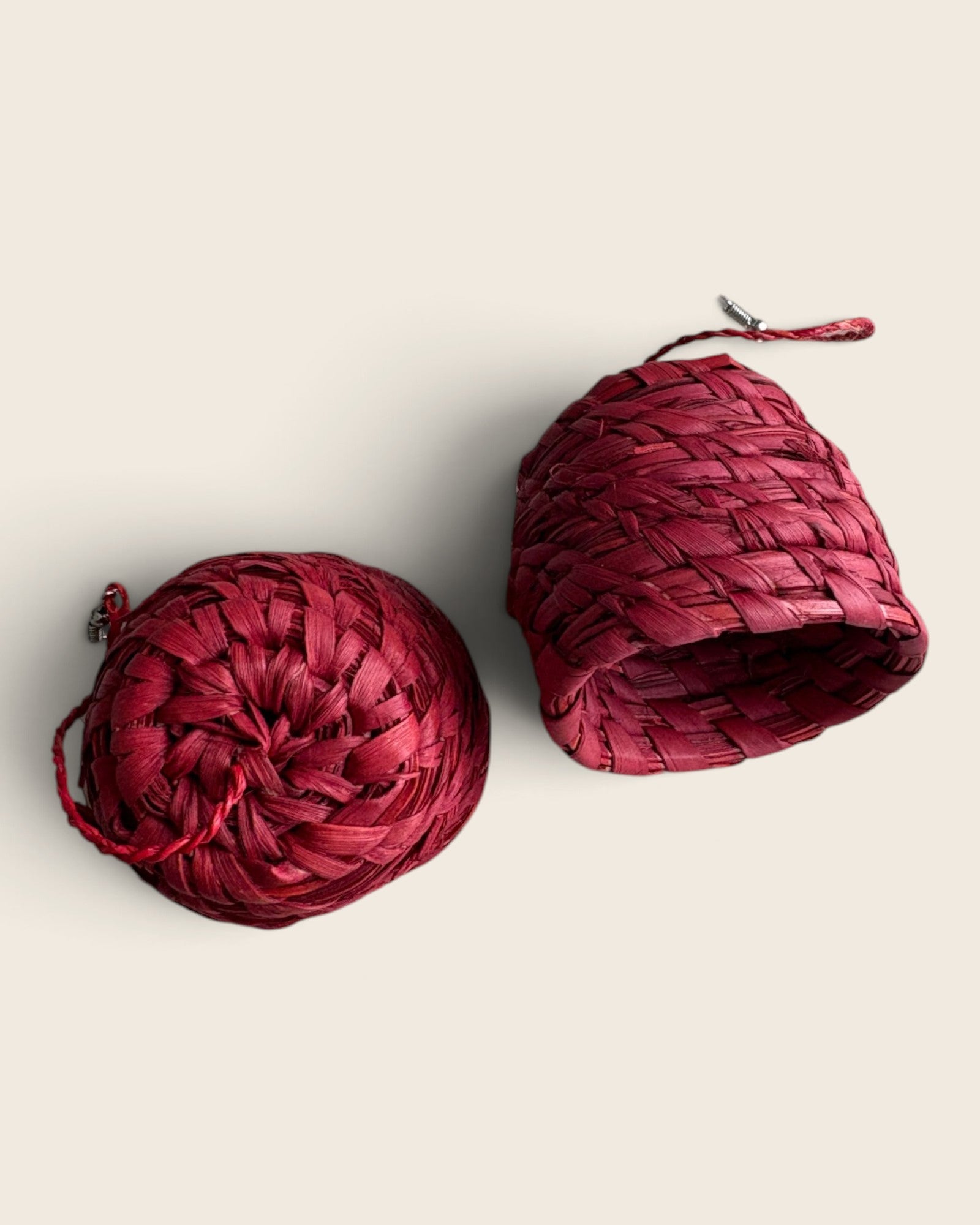 Underside of a Cinnabar Red raffia bell earring beside the coiled top, showing the woven interior, L'atelier KaAy
