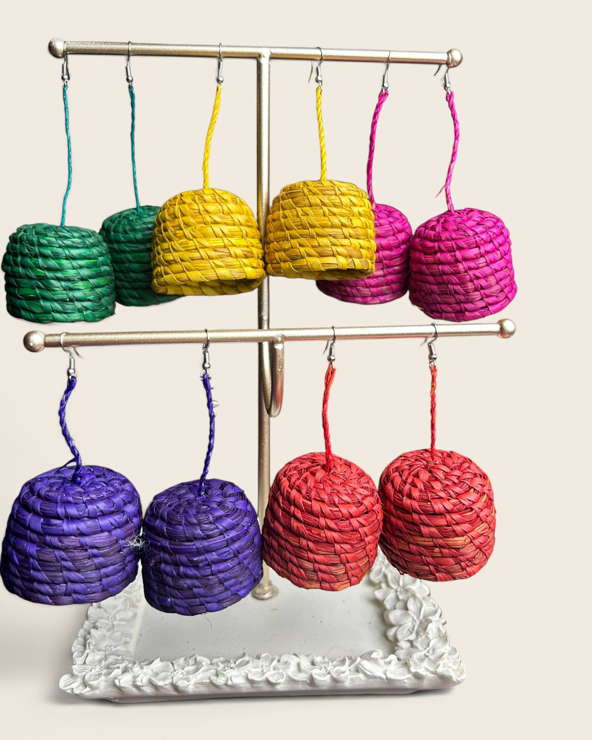 Sade raffia bell earrings in emerald, saffron gold, raspberry pink, royal purple and cinnabar red, hand-woven in Nigeria