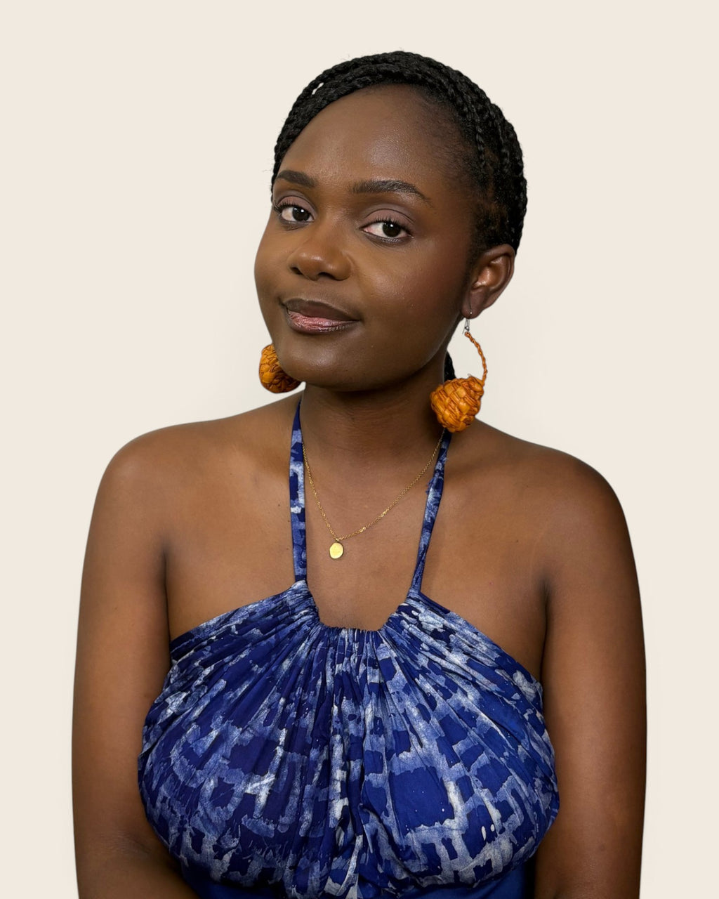 Hand-woven raffia teardrop earrings in burnt amber, seen from the front